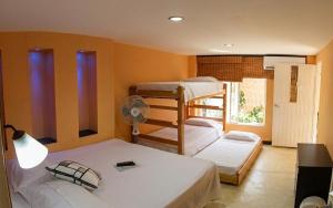 a bedroom with two bunk beds and a fan at Casa D'mer Taganga in Taganga