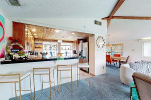 a kitchen and living room with a bar with stools at Mid-Century Modern Lake House with Private Waterfront Pool & Boat Dock in Marble Falls