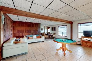 a living room with couches and a pool table at Mid-Century Modern Lake House with Private Waterfront Pool & Boat Dock in Marble Falls