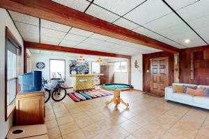 a living room with a pool table and a tv at Mid-Century Modern Lake House with Private Waterfront Pool & Boat Dock in Marble Falls +28 photos