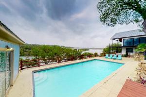 a swimming pool in front of a house at Mid-Century Modern Lake House with Private Waterfront Pool & Boat Dock in Marble Falls