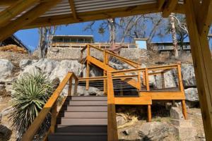 a staircase leading up to a house with rocks at Mid-Century Modern Lake House with Private Waterfront Pool & Boat Dock in Marble Falls
