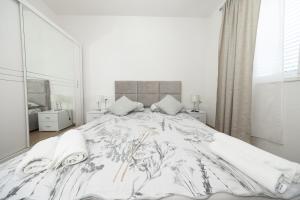 a white bedroom with a large bed and a mirror at Ilma Apartment in Trogir +28 photos