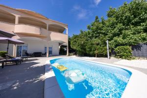a toy boat in a swimming pool next to a house at Ilma Apartment in Trogir