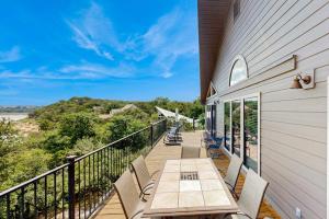 a balcony with a table and chairs on a building at Spacious Lakefront Hideaway with Decks, Grill, Billiards, Tennis & Pool in Spicewood