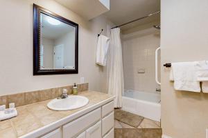 a bathroom with a sink and a tub and a mirror at Spacious Lakefront Hideaway with Decks, Grill, Billiards, Tennis & Pool in Spicewood +17 photos