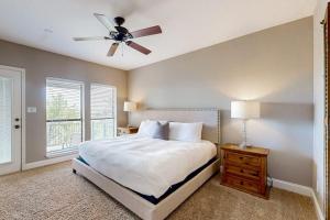 a bedroom with a bed and a ceiling fan at Spacious Lakefront Hideaway with Decks, Grill, Billiards, Tennis & Pool in Spicewood