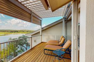 a balcony with two chairs and a table at Refined Panoramic Paradise on Lake Travis with Boat Launch and Tesla Charger in Spicewood
