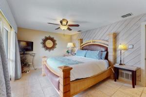 a bedroom with a large bed and a ceiling fan at Refined Panoramic Paradise on Lake Travis with Boat Launch and Tesla Charger in Spicewood