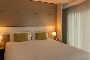 a bedroom with a large white bed with two pillows at Point Hotel in Brisbane