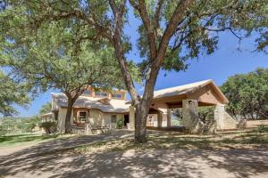a house with a tree in front of it at Regal Riverfront Home with 2 Cabins - 2 Miles to Marina in Spicewood