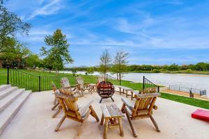 a group of chairs and tables next to a river at Waterfront Home with Kayaks, Game Room, Firepit, & Enormous Deck in Kingsland