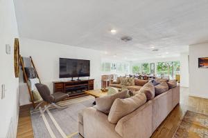 a living room with a large couch and a television at Waterfront Home with Kayaks, Game Room, Firepit, & Enormous Deck in Kingsland