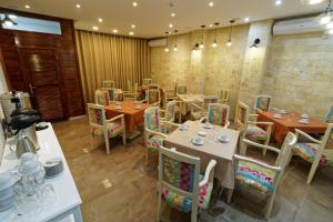 a restaurant with tables and chairs in a room at Hotel Roma in Tunis