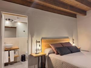 a bedroom with a bed and a bathroom with a sink at Apartament "El Castell" Casa Rural Cal Rialla in Llivia +26 photos