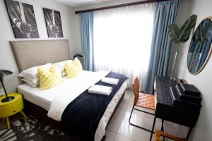 a bedroom with a large bed and a window at KADESE Holiday North Beach Durban in Durban +74 photos