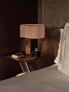 a bedside table with a lamp next to a bed at Rosewood Courchevel Le Jardin Alpin in Courchevel