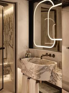 a bathroom with a marble sink and a mirror at Rosewood Courchevel Le Jardin Alpin in Courchevel