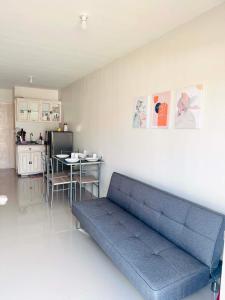 a blue couch in a living room with a table at Home Vacation in Ormoc City in Catmon