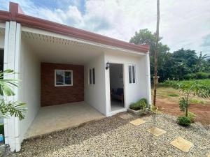 a small white house with a large garage at Home Vacation in Ormoc City in Catmon