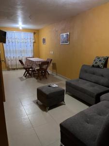ein Wohnzimmer mit Sofa und Tisch in der Unterkunft Rincón acogedor in Toluca de Lerdo