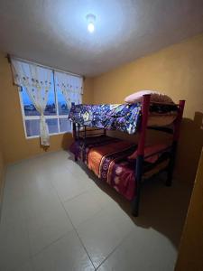ein Schlafzimmer mit einem Etagenbett und einem Fenster in der Unterkunft Rincón acogedor in Toluca de Lerdo