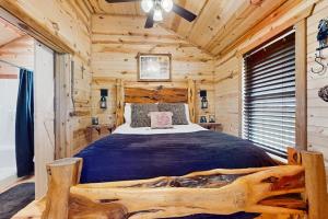 a bedroom with a bed in a log cabin at Dog-Friendly Gem on 11 Acres with Valley Views, Deck, Gas Grill, Fireplace in Fredericksburg
