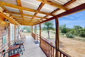 a porch with two benches and a wooden ceiling at Dog-Friendly Gem on 11 Acres with Valley Views, Deck, Gas Grill, Fireplace in Fredericksburg