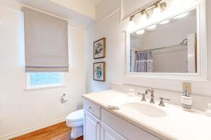 a white bathroom with a sink and a toilet at Enchanting Home with Fireplace, Full Kitchen, Patio, Central AC, & Washer/Dryer in Fredericksburg +14 photos