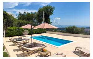 a swimming pool with lounge chairs and an umbrella at Gorgeous Home In Solin in Solin