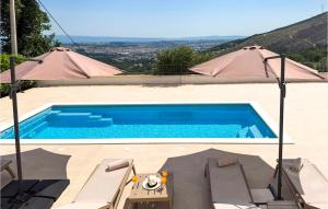 a swimming pool with a table and two tents at Gorgeous Home In Solin in Solin +33 photos