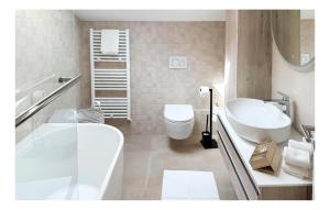 a bathroom with a tub and a toilet and a sink at Gorgeous Home In Solin in Solin