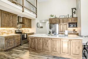 a kitchen with wooden cabinets and a large island at Expansive Getaway Near Downtown with Fast WiFi, Grill in Fredericksburg