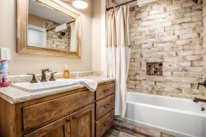 a bathroom with a sink and a tub and a mirror at Expansive Getaway Near Downtown with Fast WiFi, Grill in Fredericksburg