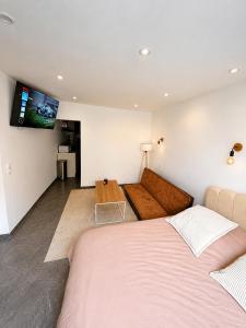 a bedroom with two beds and a couch at Le Cosy de Longwy in Longwy