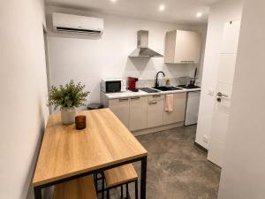 a kitchen with a wooden table and a counter top at Le Cosy de Longwy in Longwy