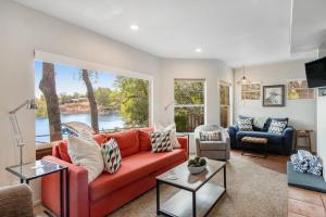 a living room with a red couch and a large window at Two-Story Waterfront Retreat with Boat Dock, Two Firepits & Two Kayaks in Burnet