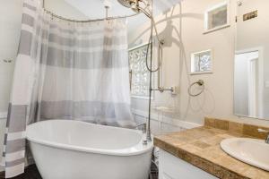a white bathroom with a tub and a sink at Two-Story Waterfront Retreat with Boat Dock, Two Firepits & Two Kayaks in Burnet +29 photos