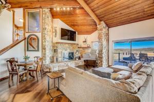 a living room with a couch and a stone fireplace at Stunning Lakefront Home with 2 Patios, Chef's Kitchen, & Lake Access in Spicewood