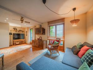 a living room with a blue couch and a tv at Panoramahaus Itter in Itter