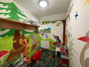 a childs room with a monkey and trees painted on the wall at Chata Nisanka in Bedřichov