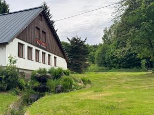 a barn with a grass field next to it at Chata Nisanka in Bedřichov +39 photos