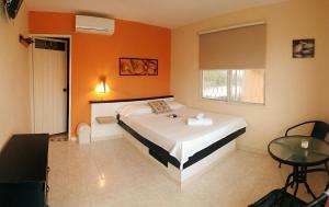 a bedroom with a bed and a glass table at Casa D'mer Taganga in Taganga