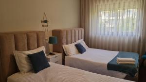 a bedroom with two beds and a window at Barra's Beach Apartment in Praia da Barra