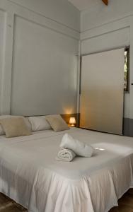 a white bed with a towel on top of it at Hostel Nosara in Playa Guiones +24 photos