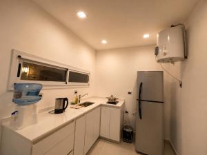 a white kitchen with a refrigerator and a sink at Departamento Parque, Asador y Pileta Privada, uso exclusivo in San Luis