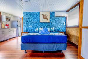 a blue bedroom with a bed with blue walls at Fare Aute Beach in Vaianae