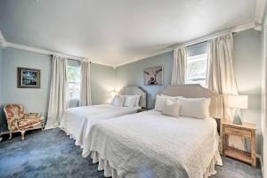 a bedroom with two beds and a chair and windows at Snowbird-Friendly House with Game Room, Full Kitchen, Balcony & W/D in Kerrville +37 photos