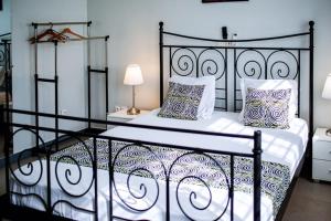 a bedroom with a black and white bed with pillows at Villa Mélaure in Abomey-Calavi