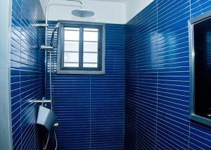 a bathroom with blue tiled walls and a window at Villa Mélaure in Abomey-Calavi +30 photos